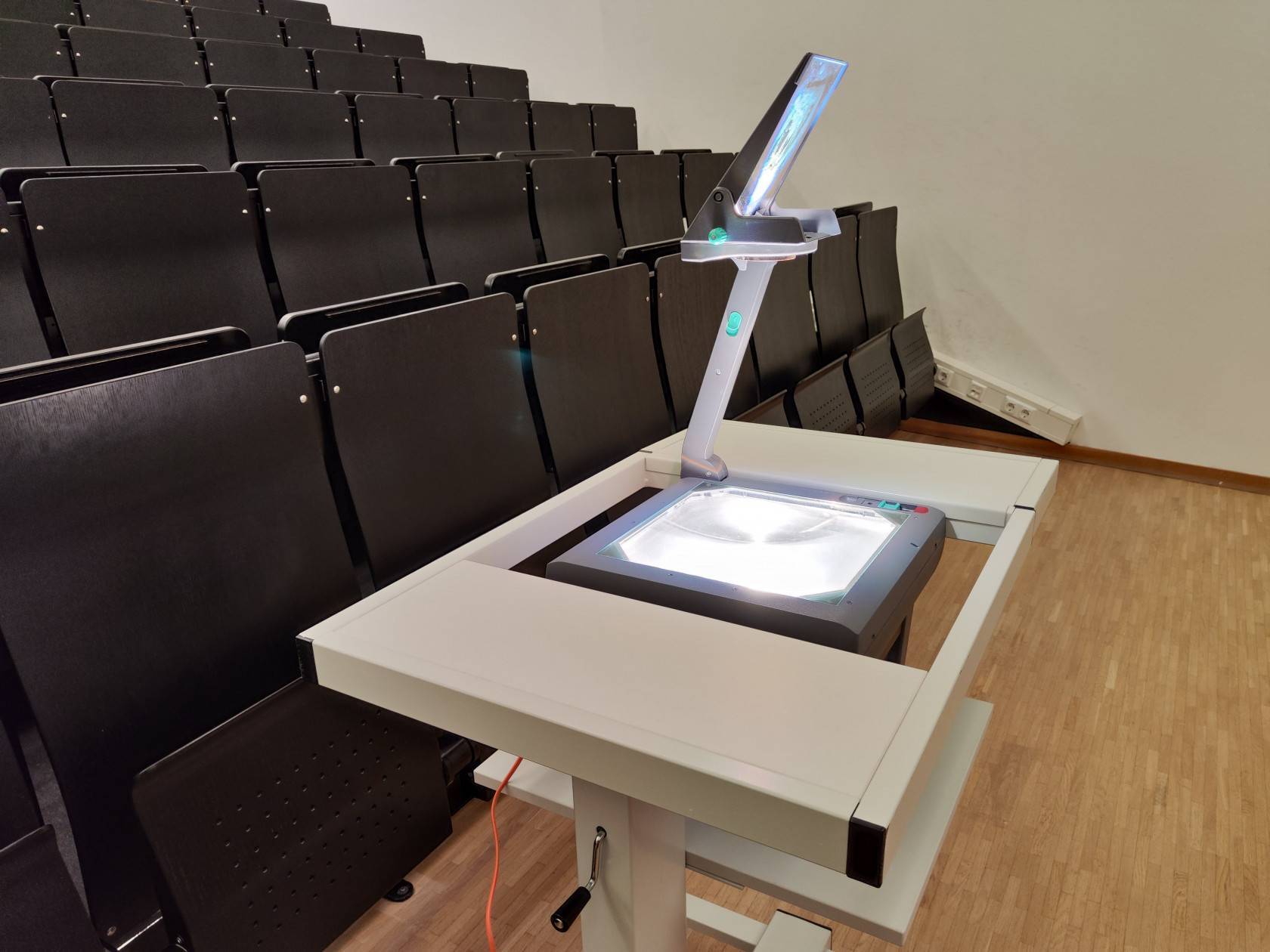 eingeschalteter Tageslichtprojektor mit aufgeklapptem Spiegel auf einem dafür speziellen Tisch
