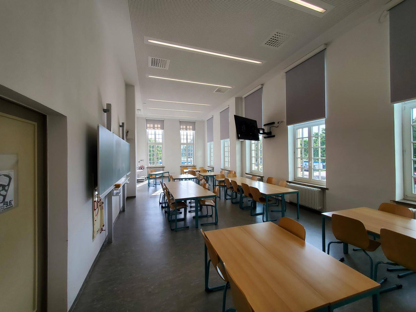 Musterbild Seminarraum Haus 3, Campus Jahnallee mit mehreren frei im Raum stehenden Tischen 