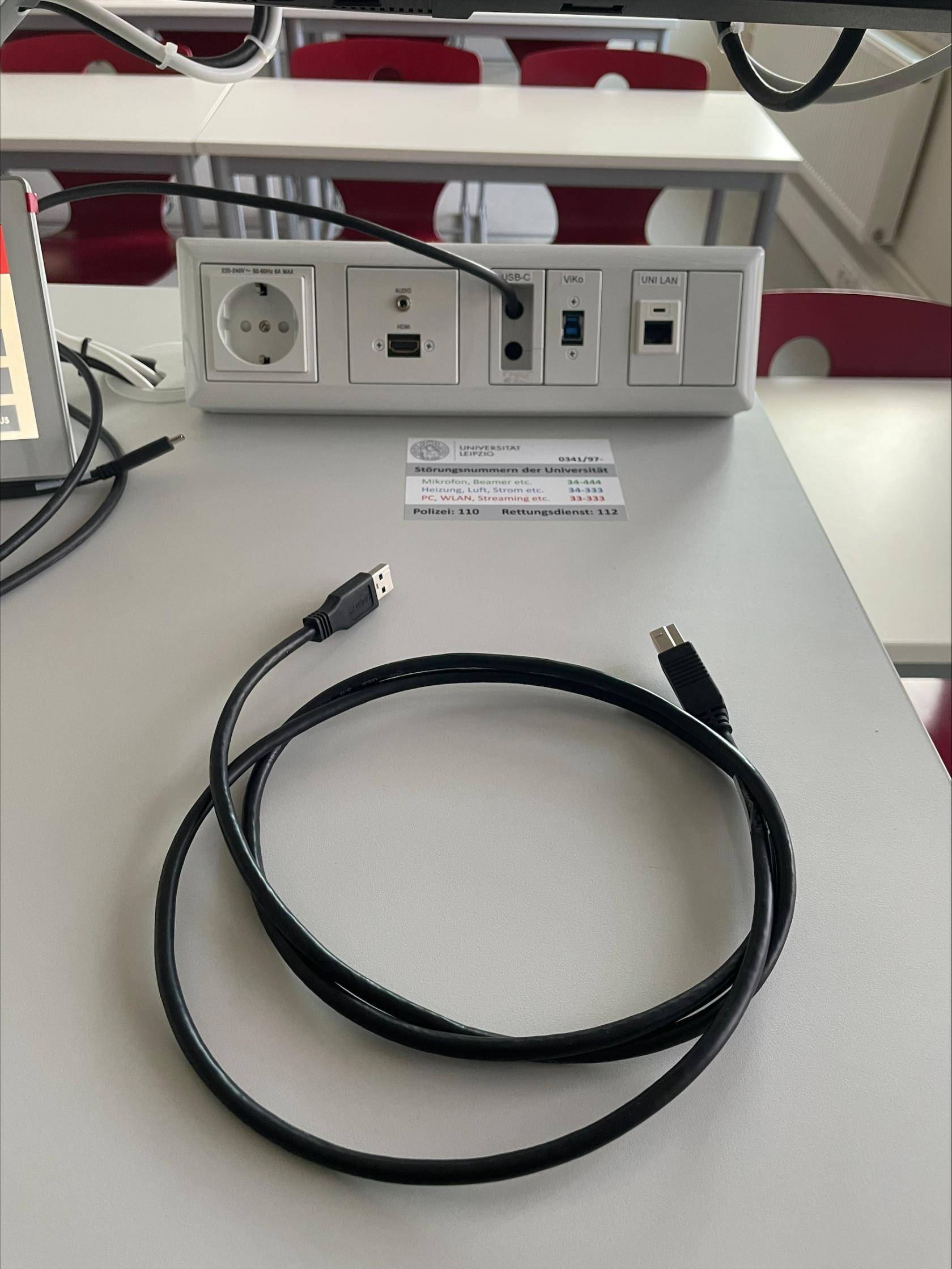 USB-B Kabel zur Nutzung der Videokonferenzanlage, oben mittig im Bild das Anschlussfeld