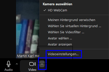 Ansicht eines Zoom Meeting. In den unteren linken Ecke sind die Optionen neben dem Button "Video" geöffnet und der Button "Videoeinstellungen" darin hervorgehoben.