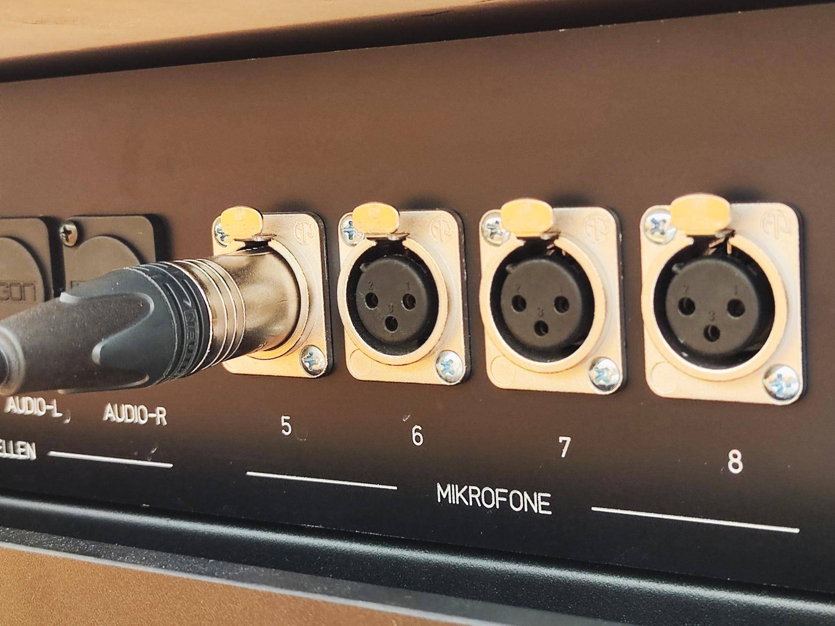 Steckfeld mit vier Mikrofonanschlüssen, die mit 5 bis 8 beschriftet sind, Audioanschluss steckt im Anschluss 5