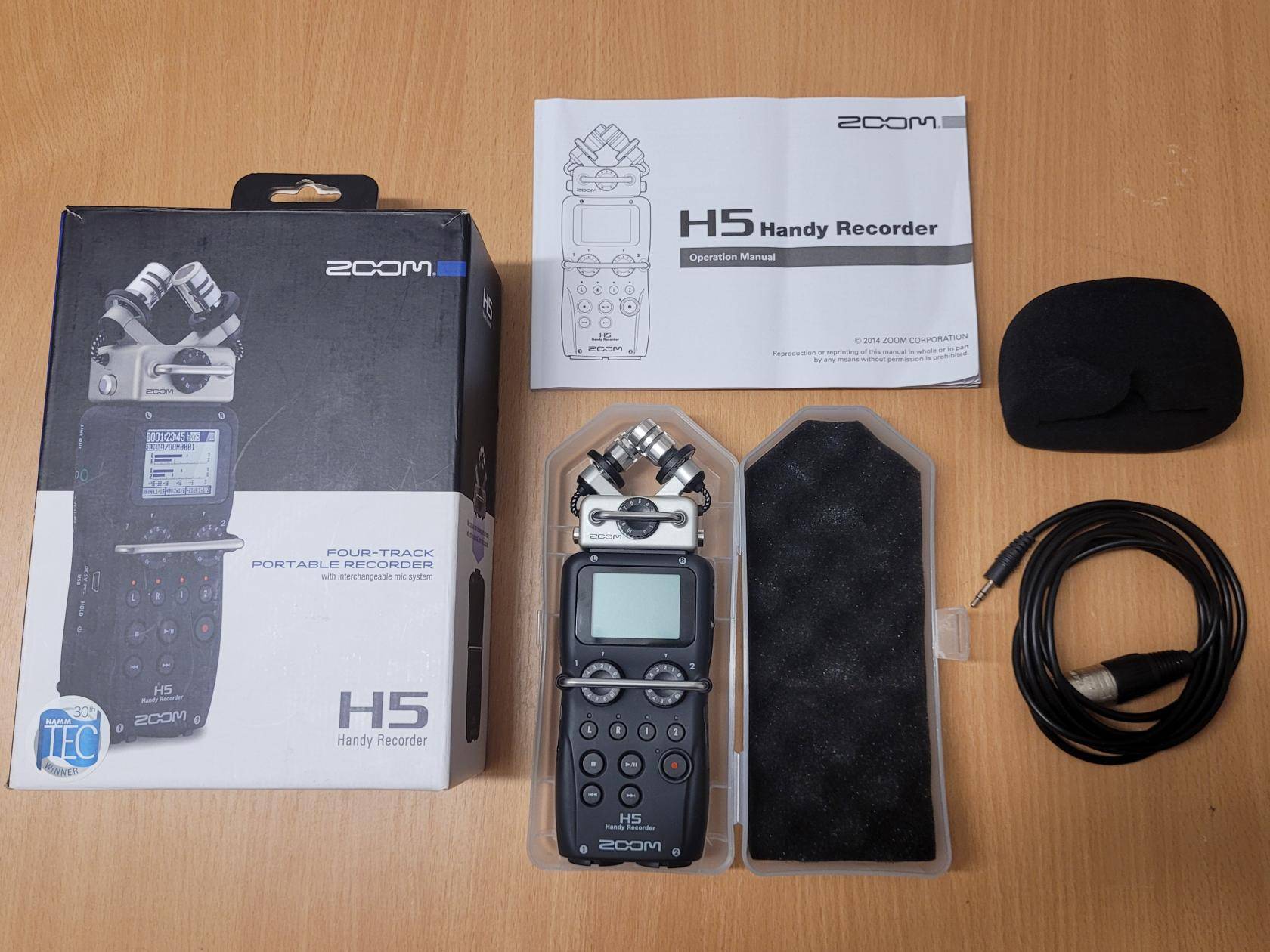 Zubehör des Recorders auf Tisch: Karton, Recorder in einem Plastikcase, Windschutz, Anleitung, Adapterkabel XLR auf 3,5mm Klinke