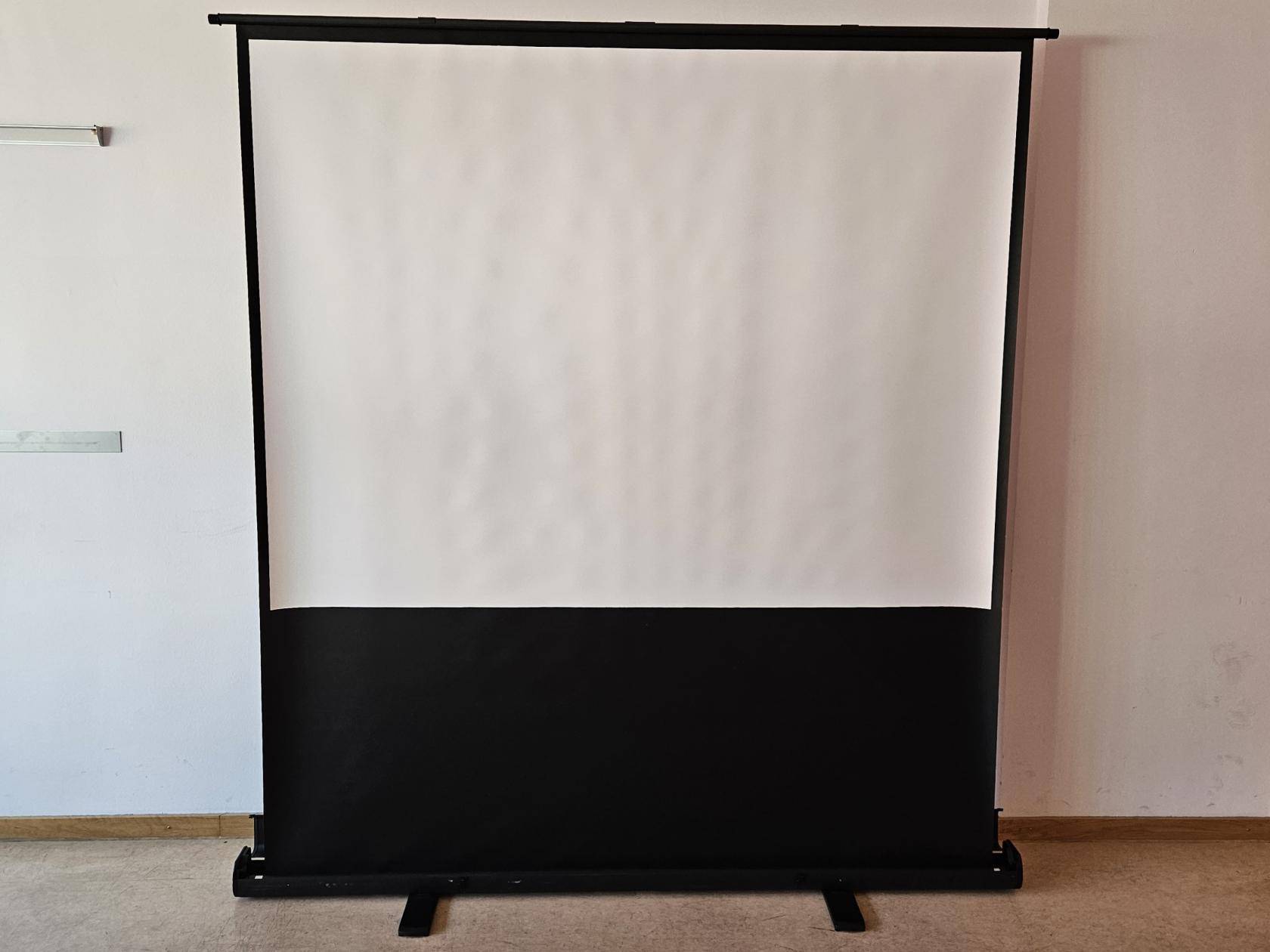 fertig aufgestellte Leinwand vor einer Wand